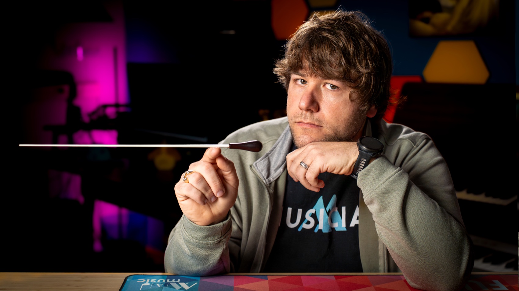 Chase Jamison holding a conducting baton in his studio